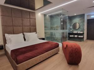 a bedroom with a large bed and a glass wall at Motel Unique Private Suites in Leça da Palmeira