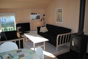 a living room with a black couch and a tv at Holiday Home Near Hvalpsund in Farsø