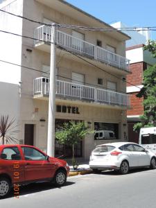 dos coches estacionados frente a un edificio en Hotel Kube en Mar del Plata
