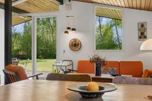 a dining room with orange chairs and a table at Nostalgic 1960S Idyll in Kulhuse