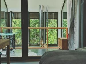 a bedroom with windows and a bed and a table at W Pelniku in Pelnik