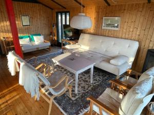 a living room with a white couch and a table at 70S Charm Just 300 M From The Beach in Blokhus