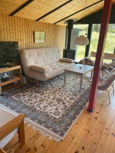 a living room with a white couch and a table at 70S Charm Just 300 M From The Beach in Blokhus