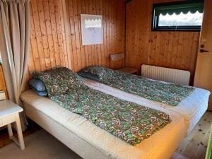 a bedroom with two beds in a wooden room at 70S Charm Just 300 M From The Beach in Blokhus