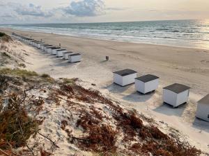 a row of white benches on the beach at 70S Charm Just 300 M From The Beach in Blokhus +12 photos