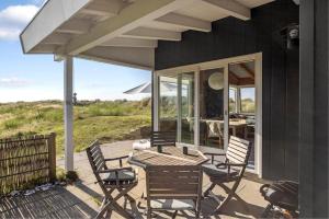 a patio with a table and chairs on a house at Simple Summer Living In Magical Setting in Nykøbing Sjælland