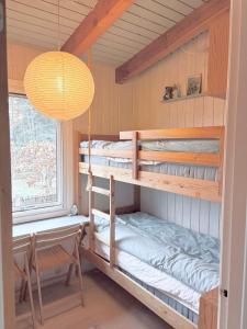 a room with two bunk beds and a chandelier at Simple Summer Living In Magical Setting in Nykøbing Sjælland