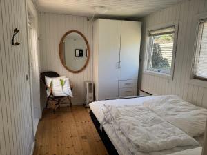 a bedroom with a bed and a mirror and a chair at Holiday Home Near Nordstrand Nykøbing Sj in Nykøbing Sjælland