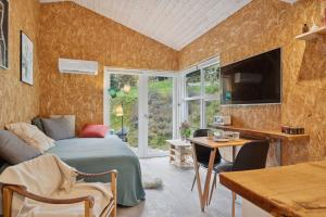 a bedroom with a bed and a television and a table at Small Oasis Near Coast And Town in Ebeltoft