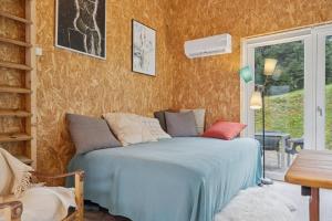 a bedroom with a bed and a table and a window at Small Oasis Near Coast And Town in Ebeltoft