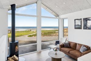 a living room with a fireplace and a view of the ocean at Seaside Cottage With A Stunning View in Allingåbro