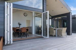 a patio with a table and chairs and a clock at Seaside Cottage With A Stunning View in Allingåbro