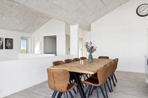 a dining room with a wooden table and chairs at Seaside Cottage With A Stunning View in Allingåbro