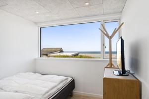 a bedroom with a bed and a large window at Seaside Cottage With A Stunning View in Allingåbro