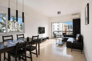a dining room and living room with a table and chairs at Urban Condo Promitheos in Nicosia +36 photos