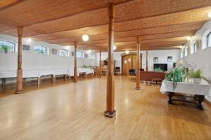 a large room with wooden ceilings and tables and chairs at Margretehøj Manor In Scenic Surroundings in Grenå
