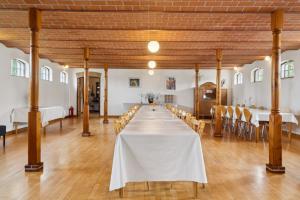 a long table in a large room with tables and chairs at Margretehøj Manor In Scenic Surroundings in Grenå