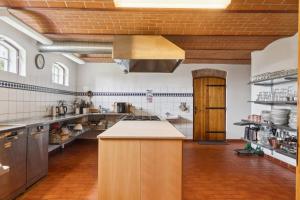 a large kitchen with a counter in the middle at Margretehøj Manor In Scenic Surroundings in Grenå