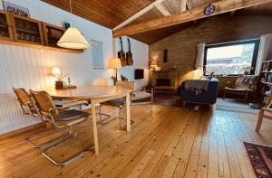 a dining room with a wooden table and chairs at Charming And Cozy Cottage in Tranekær