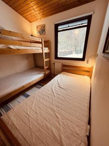 a bedroom with two bunk beds and a window at Charming And Cozy Cottage in Tranekær