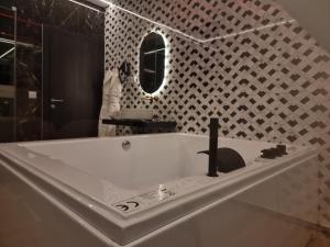 a white bath tub in a bathroom with a mirror at Motel Unique Private Suites in Leça da Palmeira