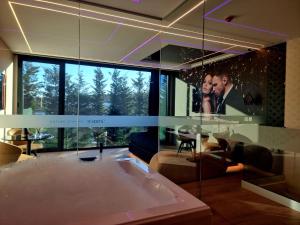 a living room with a bath tub and a large window at Motel Unique Private Suites in Leça da Palmeira +5 photos