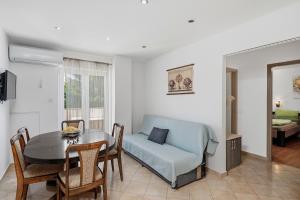 a living room with a table and a blue couch at Guesthouse Marija II in Lopar