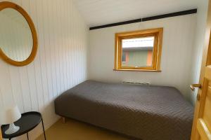 a small bedroom with a bed and a mirror at The Pearl In Marielyst in Bøtø By