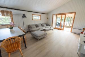 a living room with a couch and a table at The Pearl In Marielyst in Bøtø By +7 photos