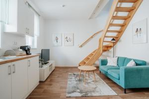 a living room with a blue couch and stairs at Villa Matylda in Mariánské Lázně