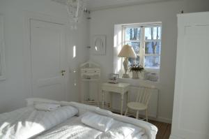 a white bedroom with a bed and a desk and a window at Large Holiday Home In Seaside Hotel Style in Ans