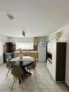 a kitchen with a table and chairs and a refrigerator at infinity sky stay in episkopi-heraklion