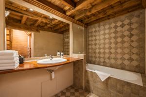 a bathroom with a sink and a tub at Hôtel Amphithéâtre in Arles +52 photos