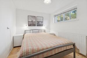 a bedroom with a bed and two windows at Family-Friendly Beachside Holiday Home in Rønne