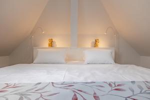 a bedroom with a white bed with two pillows at Villa Matylda in Mariánské Lázně