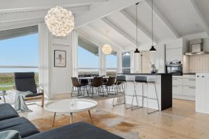 a kitchen and living room with a table and chairs at Cozy Holiday Home On Orø in Orø