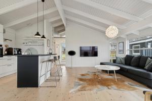 a kitchen and living room with a couch and a table at Cozy Holiday Home On Orø in Orø +21 photos