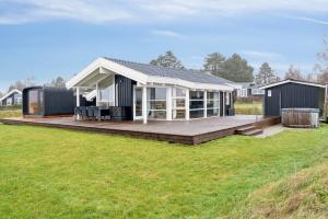 a modular home with a large deck in a field at Cozy Holiday Home On Orø in Orø