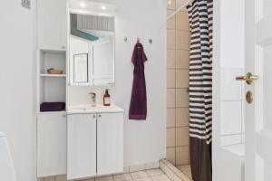 a bathroom with white cabinets and a sink at Super Nice Holiday Home With Whirlpool in Højslev