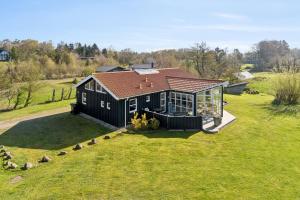 a black house with a brown roof on a green field at Super Nice Holiday Home With Whirlpool in Højslev