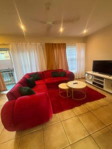 a living room with a red couch and a table at Success Guesthouse in Nelspruit