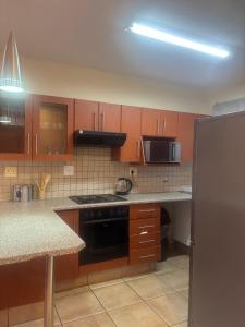 a kitchen with wooden cabinets and a stove top oven at Success Guesthouse in Nelspruit +14 photos