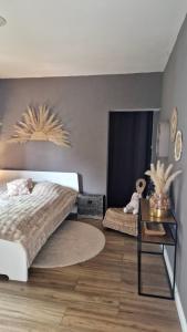 a bedroom with a large bed and a table at Écurie deL Luna in Cré-sur-Loir