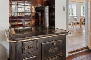 an old stove in a room with a dining room at Idyllic Half-Timbered House For 10 Guests in Kettinge