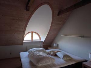 a bed in a room with an arched window at Idyllic Half-Timbered House For 10 Guests in Kettinge