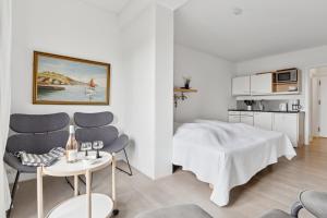 a bedroom with a bed and a table and chairs at Pension Koch Apartment 6 in Gudhjem