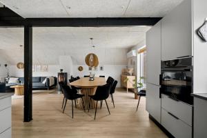 a kitchen and dining room with a table and chairs at Holiday Home With Spa Sauna And Hot Tub in Farsø