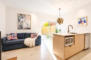 a kitchen and living room with a blue couch at Jolie Condo Great Location 2BD presented by TripMontreal I in Montreal