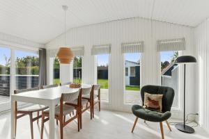 a dining room with a white table and chairs at Quiet Holiday Home With Annex And Great Outdoor in Bogø By