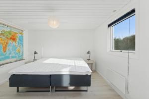 a white bedroom with a bed and a window at Quiet Holiday Home With Annex And Great Outdoor in Bogø By